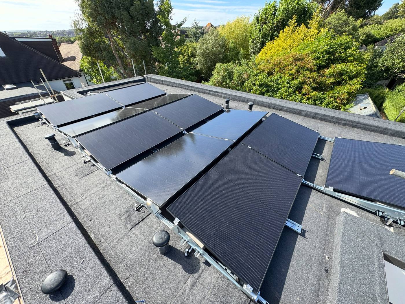 Black solar PV panels mounted in rows on a flat roof